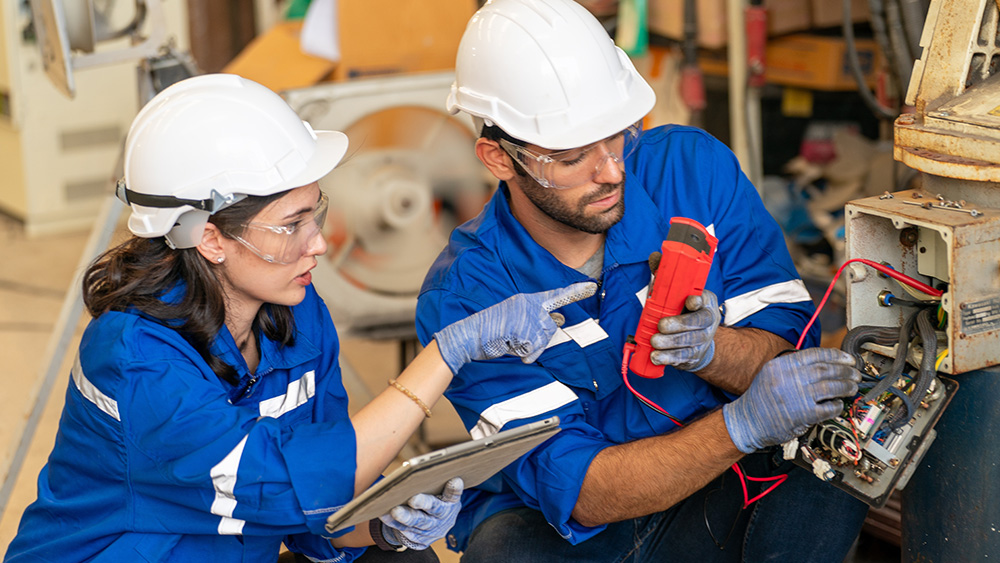 Two workers testing electricals