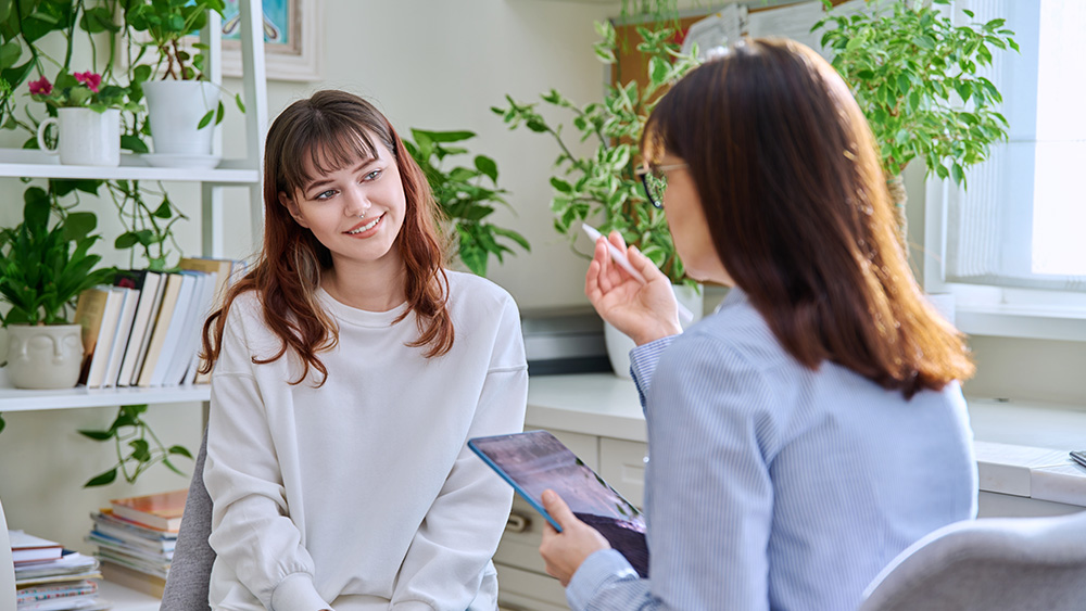 Two people in plant filled office chatting