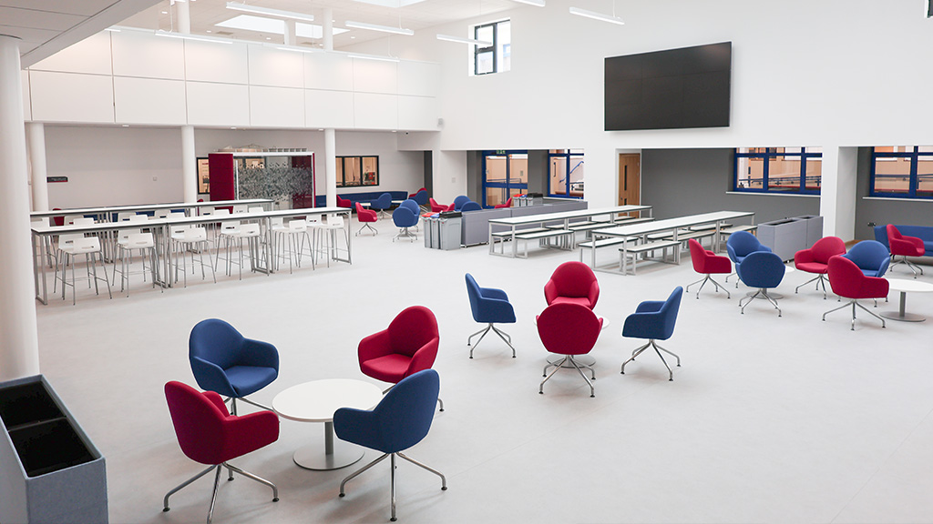 Photograph of the new social space in Gorseinon. A big open plan area with new seating and a high roof with skylights