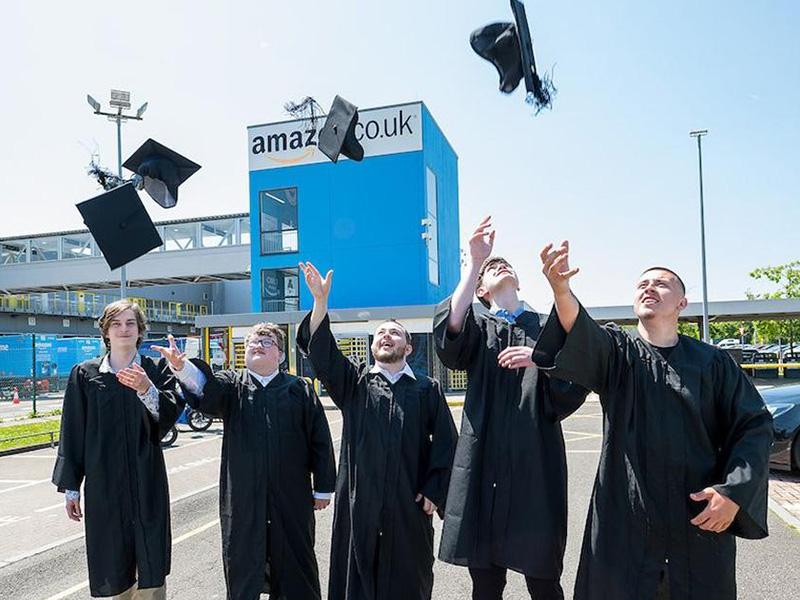 ILS students outside amazon, throwing their graduation hats in the air