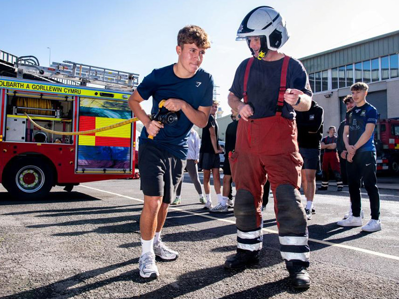 Students with fireman and hosepipe