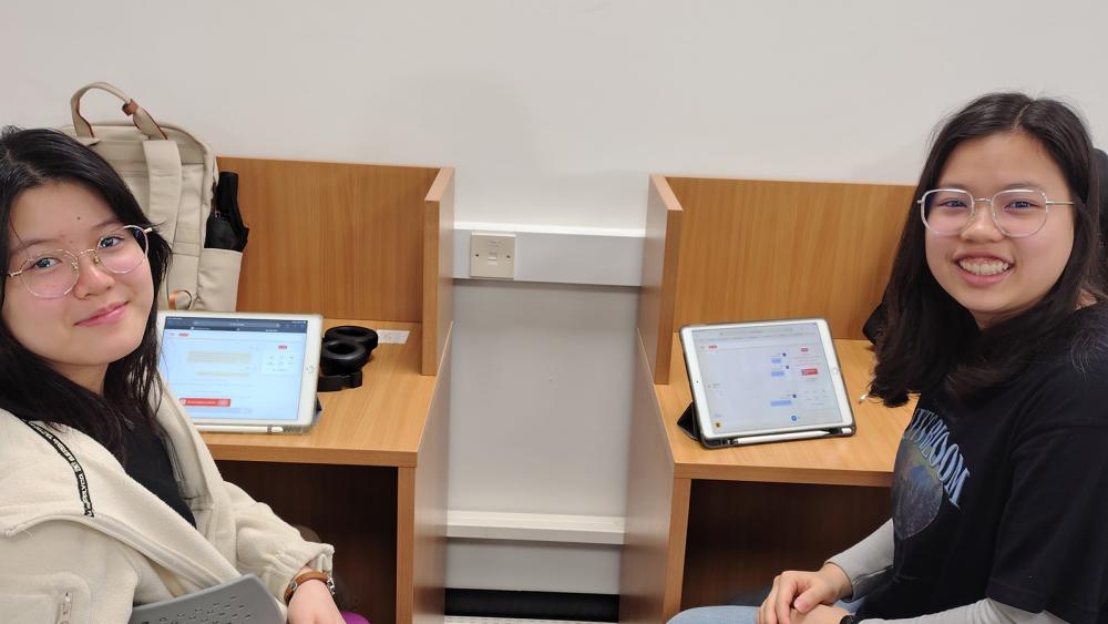 Two international students at desks