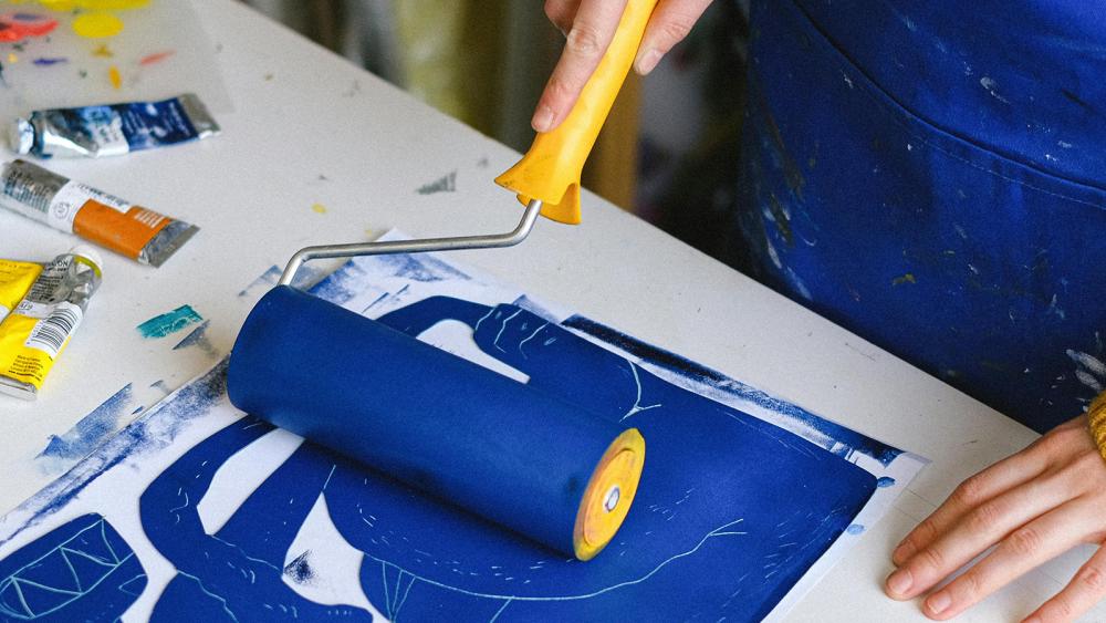 Close up of someone with a roller making prints