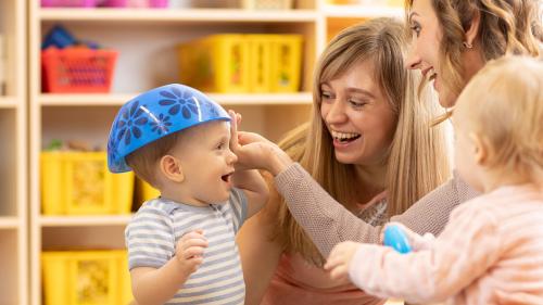 Nursery staff looking after young children and having fun