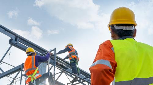 Construction manager watching workers at height