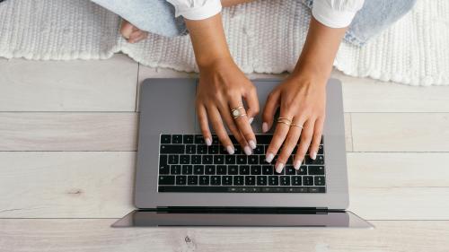 view of laptop with someone typing