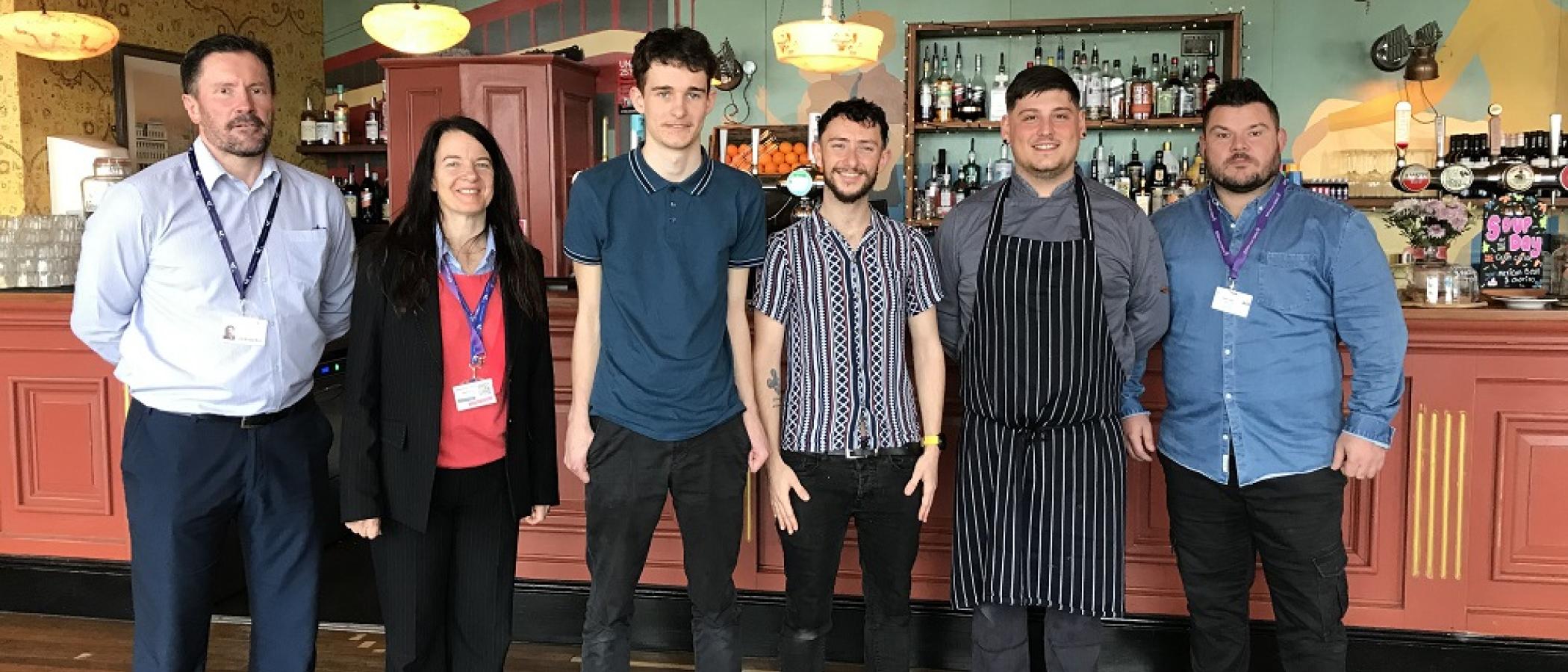 College staff, student and manager at Croeso Lounge, Mumble. Matthew Jones (Assistant Learning Area Manager), Angela Smith (ILS Tutor/Assessor), Ethan Scott, Dan Kristof (Manager, Croeso Lounge), Head Chef, Ryan Bath (ILS job coach). 