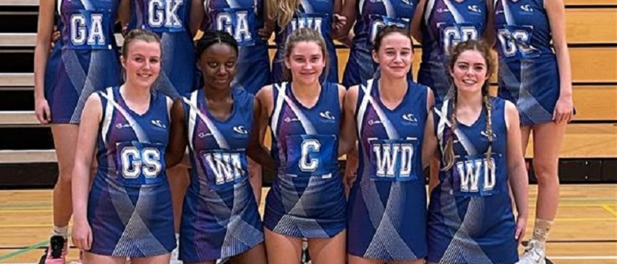Gower College Swansea's netball team with the AOC sport sign. 