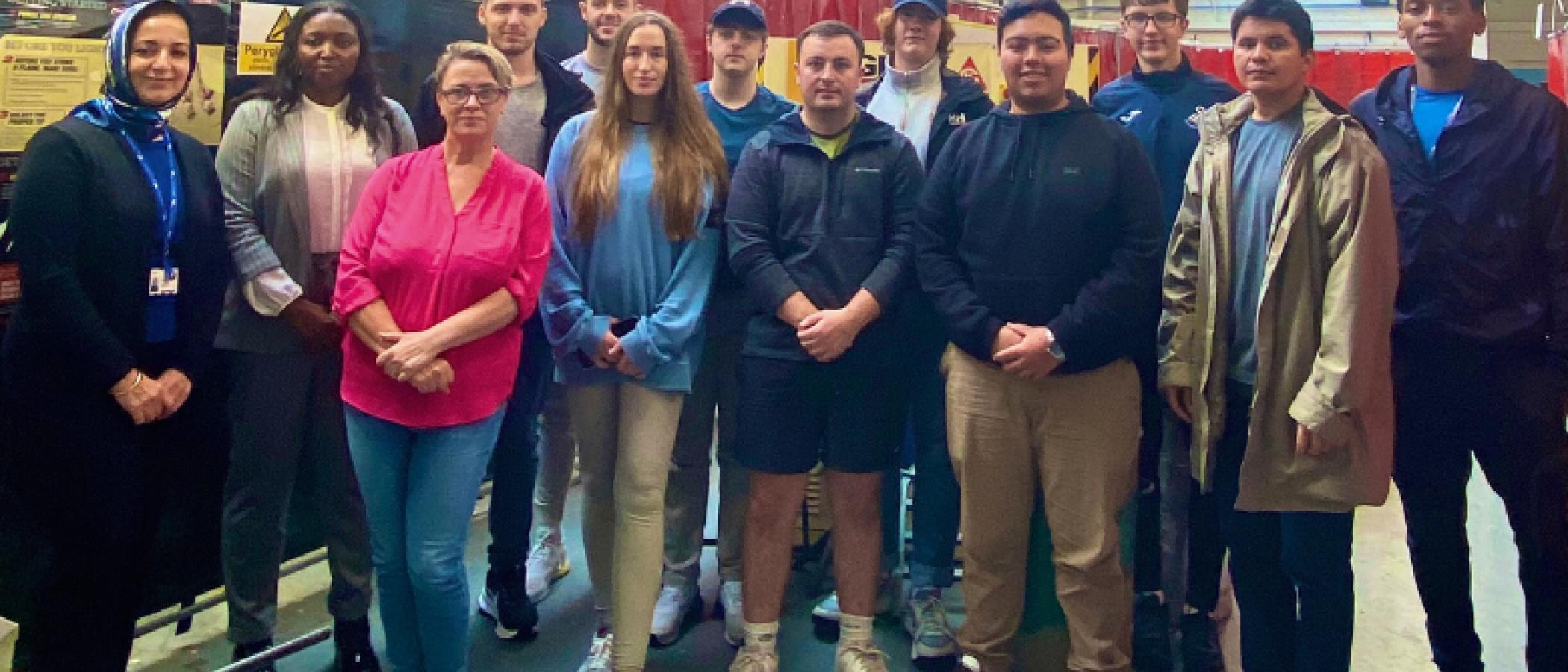 Access to Engineering staff and students standing in an engineering workshop , looking at the camera