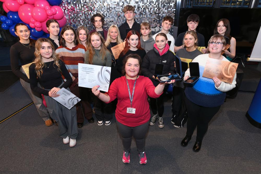 Students holding medals and certificates