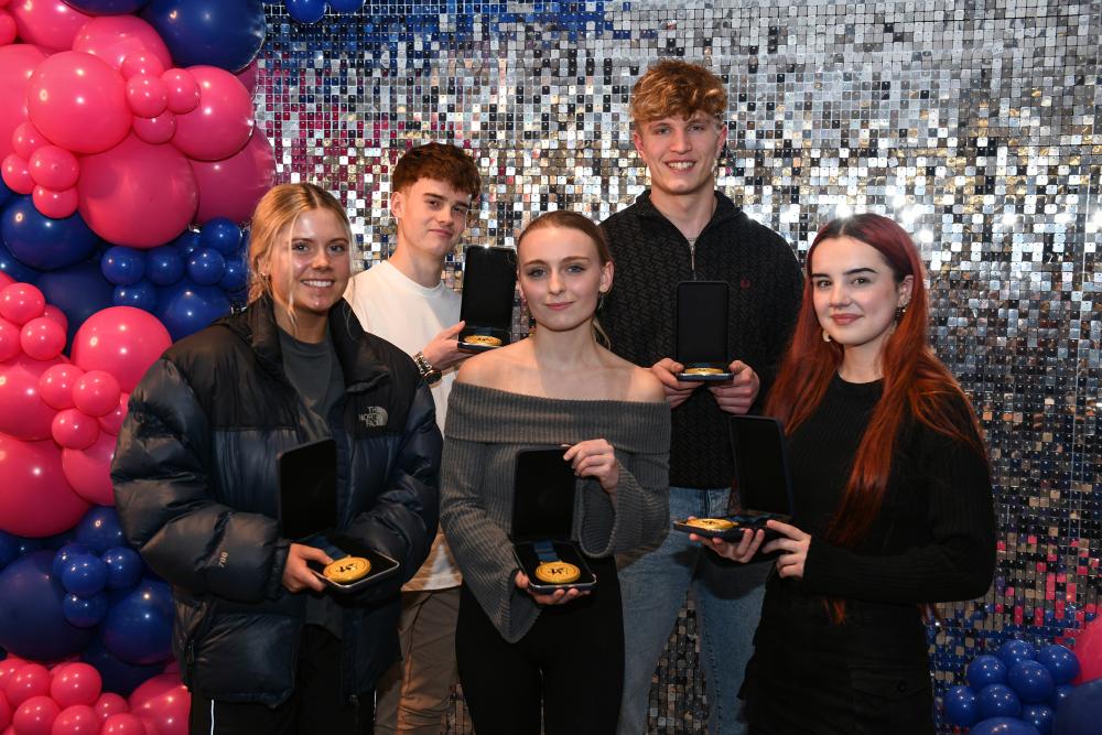 Students holding medals and certificates