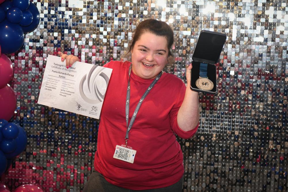 Students holding medals and certificates