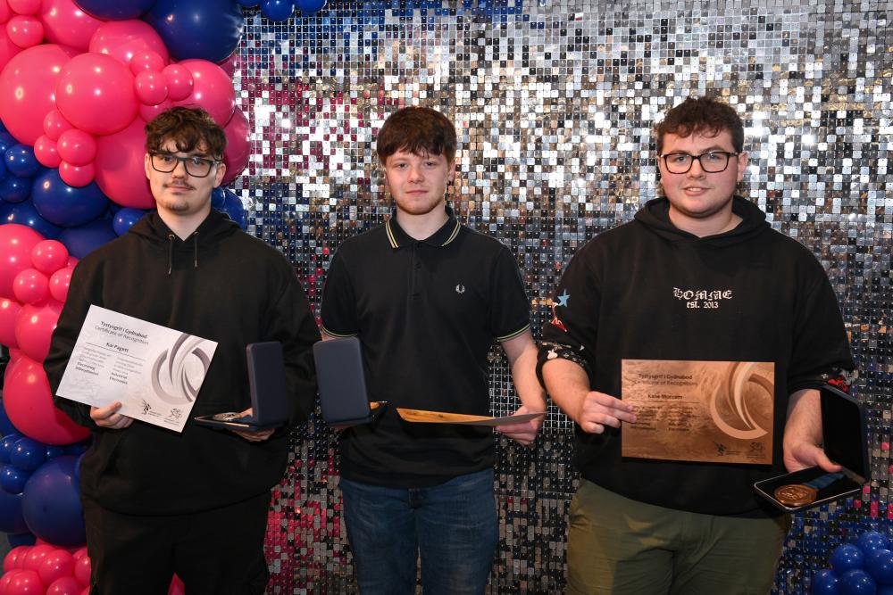 Students holding medals and certificates