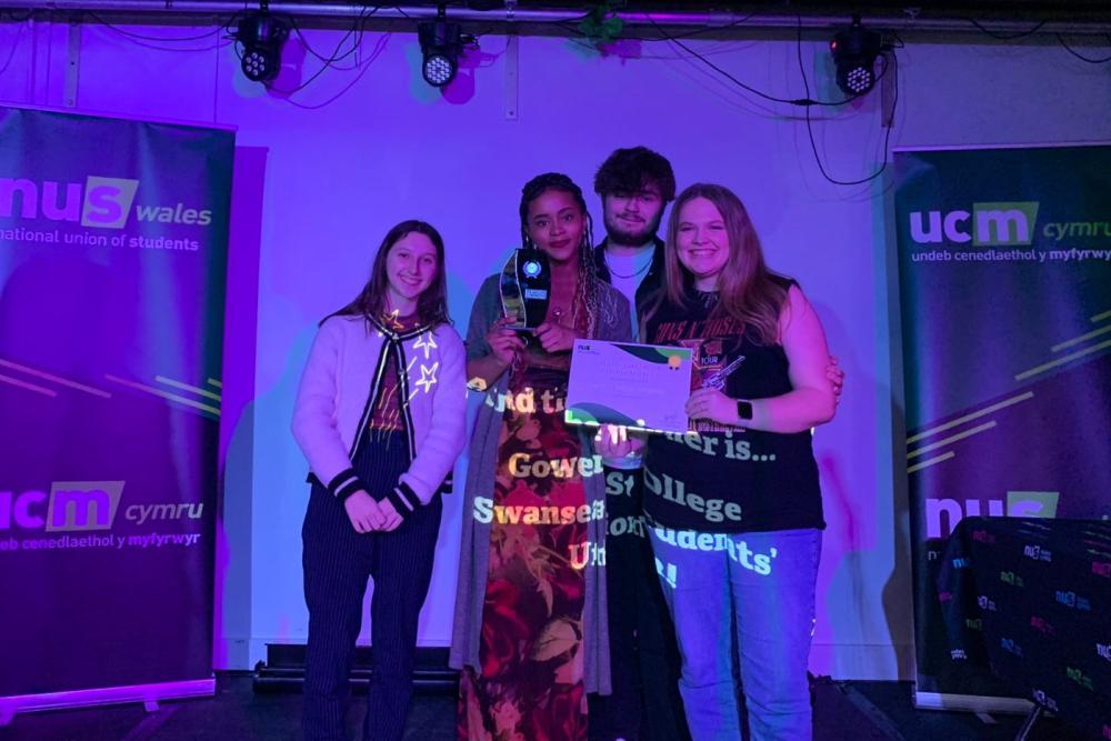 Grŵp yn sefyll ar y llwyfan