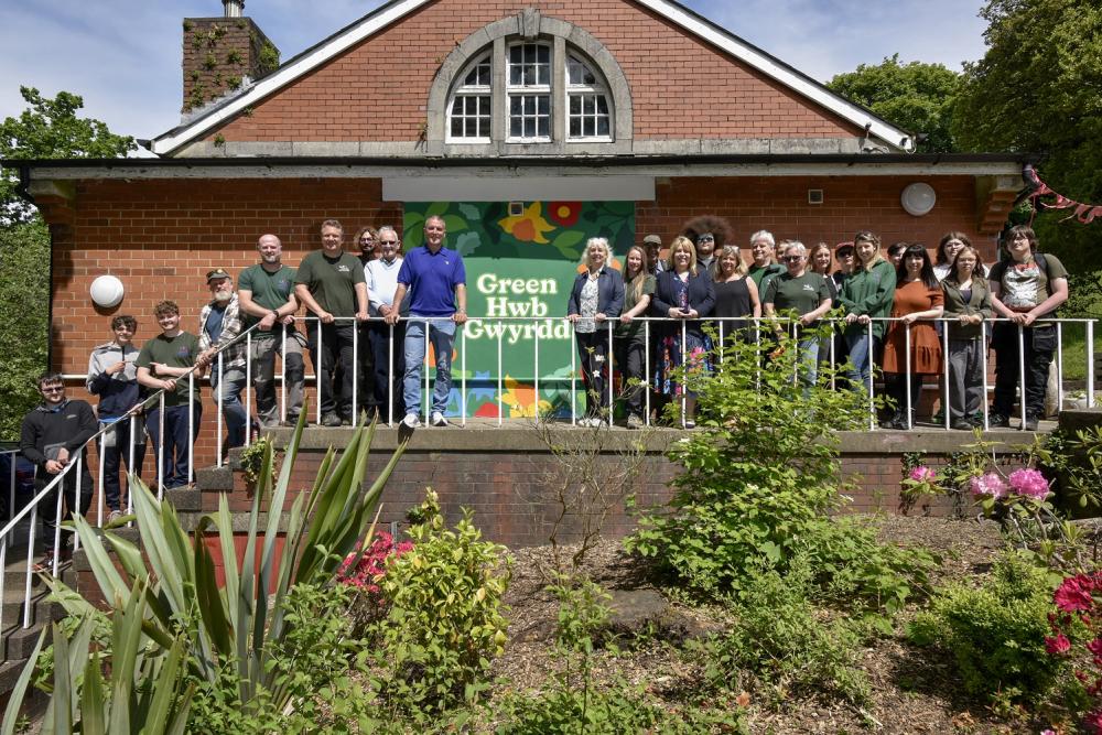 Group standing outside brick building with mural
