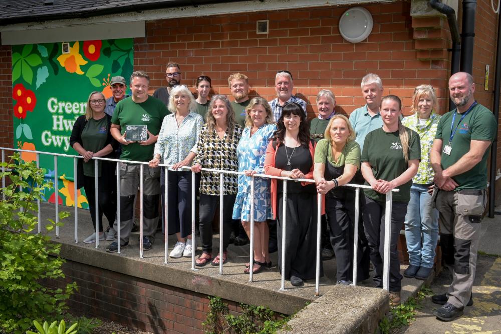 Group of people in the sunshine, holding award