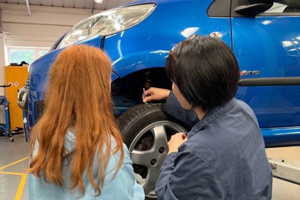 Tutor showing student how to check the tread depth on tyre
