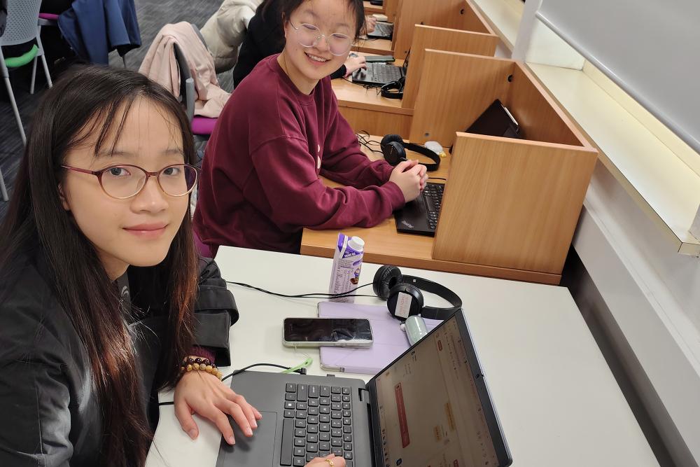 Two international students at desks