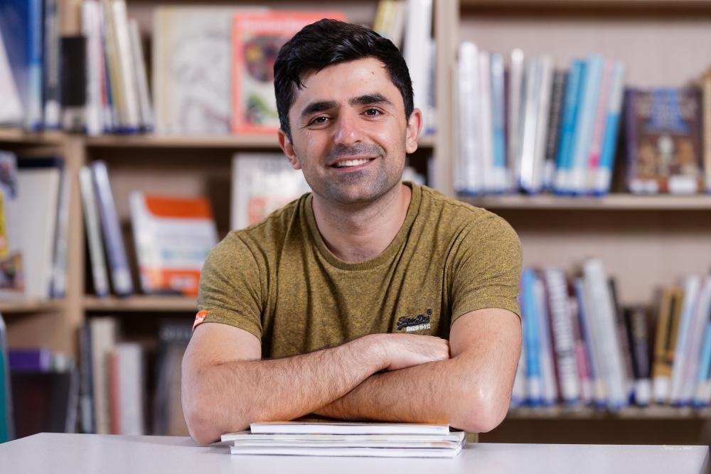 Hisham sitting in the library