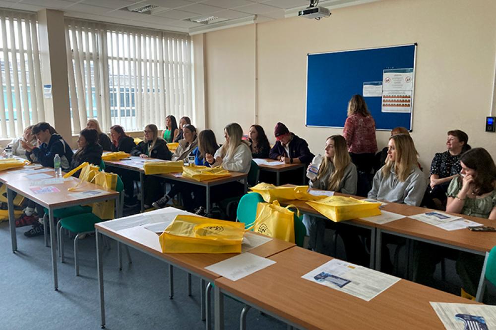 Learners sitting at table learning midwifery with dolls