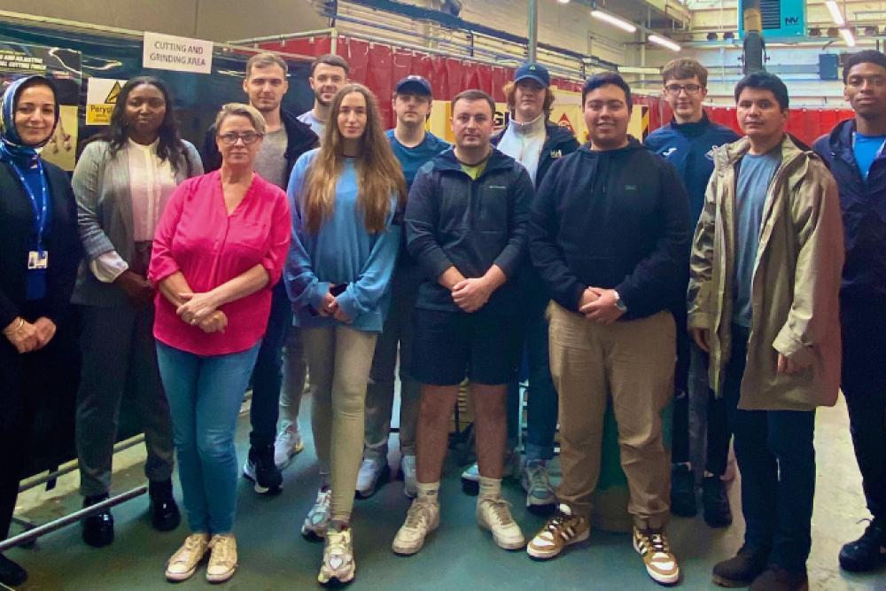 Access to Engineering staff and students standing in an engineering workshop , looking at the camera