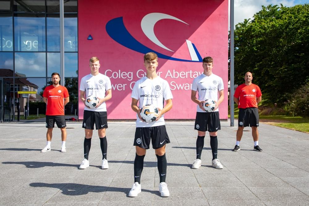 Three Pro:Direct players in their kit and two lecturers/coaches standing in V-formation in front of Tycoch Campus