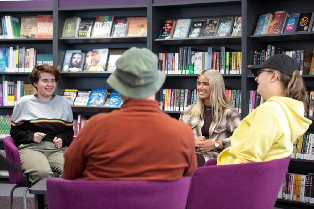 Group of students having a chat in a library